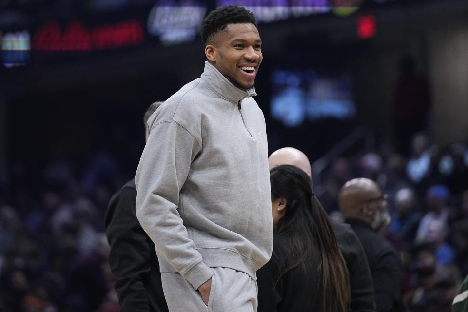 Milwaukee Bucks forward Giannis Antetokounmpo, who did not dress for the game, smiles during a timeout in the first half of the team's NBA basketball game against the Cleveland Cavaliers, Wednesday, Jan. 17, 2024, in Cleveland. (AP Photo/Sue Ogrocki)