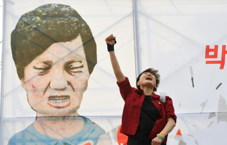 A protester shouts slogans in front of a caricature of South Korea's President Park Geun-Hye during a rally urging the impeachment of the president in Seoul on December 7, 2016