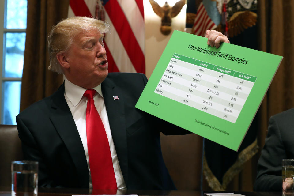 President Donald Trump holds up examples of tariffs, Thursday, Jan. 24, 2019, in the Cabinet Room of the White House in Washington. (AP Photo/Jacquelyn Martin)