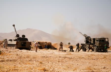 FILE PHOTO: Hezbollah fighters stand near military tanks in Western Qalamoun, Syria August 23, 2017. REUTERS/Omar Sanadiki/File Photo