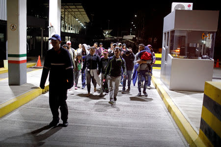 People belonging to a caravan of migrants from Honduras en route to the United States, walk at the border crossing to Mexico, in Hidalgo, Mexico, January 18, 2019. REUTERS/Jose Cabezas