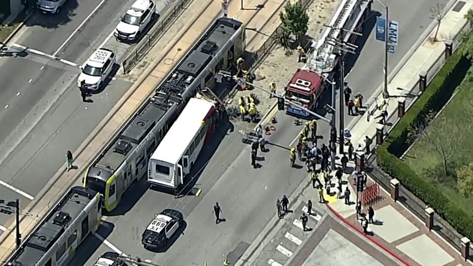 In this aerial still image provided by KABC-TV, firefighters respond to the scene of an accident where a shuttle bus collided with a Metro light rail train on Tuesday, April 30, 2024, in Los Angeles. (KABC via AP)