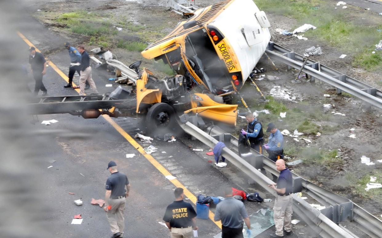 Police stand near the wreckage of a school bus on Interstate 80 following an accident with a dump truck in Mount Olive Township - REUTERS