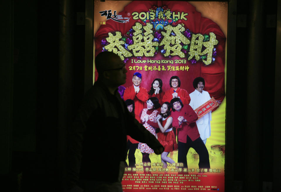 In this Wednesday Feb. 13, 2013 photo, a man walks past the advertisement of a Hong Kong movie " I Love Hong Kong 2013 " in Hong Kong. Tens of millions of film fanatics are entering theaters around Asia during the long Lunar New Year holiday. This year's Hong Kong holiday crop includes “Journey to the West: Conquering the Demons,” a prequel to the classic Chinese fable, and “I Love Hong Kong 2013,” a super-light comedy with an all-star cast and a crowd-pleasing happy ending. Explaining her preference for watching locally-produced comedies, Hong Kong movie-goer Christine Lam said it reinforced the spirit of the season. (AP Photo/Vincent Yu)