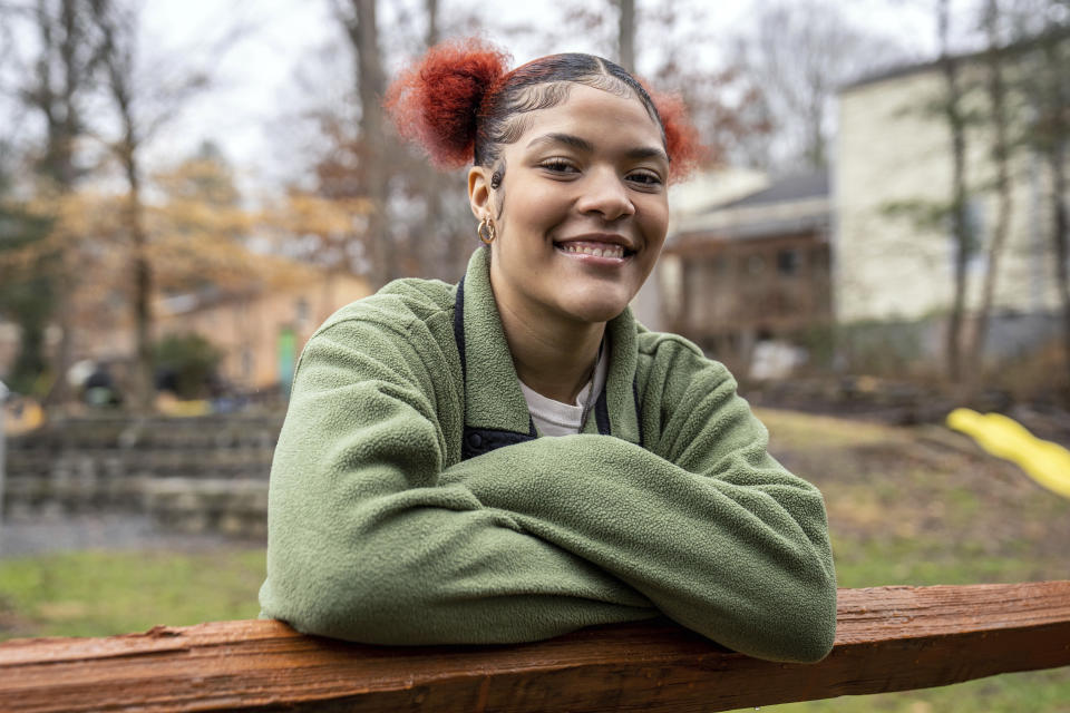 Kailani Taylor-Cribb stands for a portrait at a neighborhood community garden in Asheville, N.C., on Tuesday, Jan. 31, 2023. In December, Kailani moved to North Carolina to make a new start. She teaches dance to elementary school kids now. In January, she passed her high school equivalency exams, and she plans to study choreography. (AP Photo/Kathy Kmonicek)