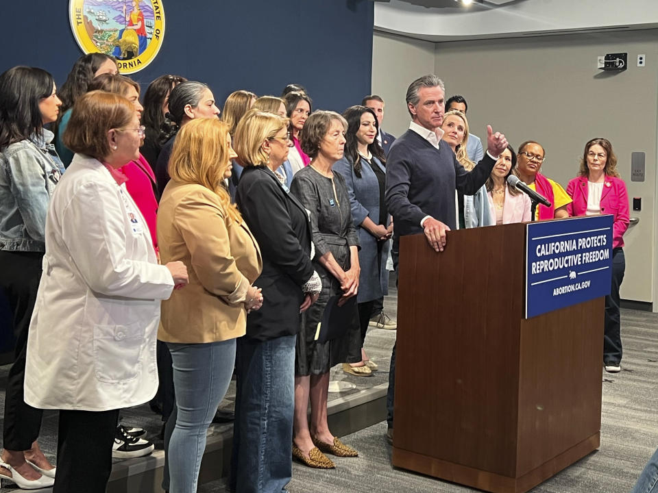 Joined by the state Legislative Women's Caucus and advocates, California Gov. Gavin Newsom speaks during a news conference, Wednesday, April 24, 2024, in Sacramento, Calif., to announce legislation that would help Arizona women access abortions. The proposal would circumvent a ban on nearly all abortions in Arizona by allowing Arizona doctors to give their patients abortions in California. (AP Photo/Sophie Austin)