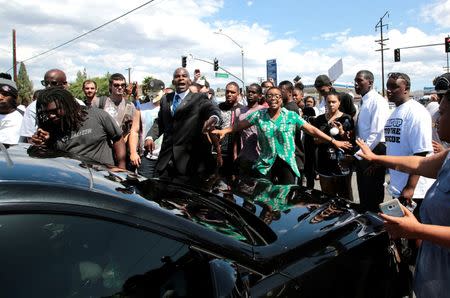 Protester leaders try to defuse an encounter with a motorist and protesters near the site where an unarmed black man was fatally shot by police on Tuesday in El Cajon, California. REUTERS/Earnie Grafton