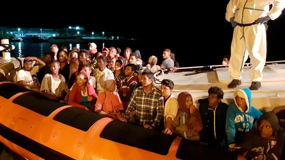 Flüchtlinge bereiten sich darauf vor, bei ihrer Ankunft im Hafen von Lampedusa aus einem Beiboot zu steigen (Archiv).