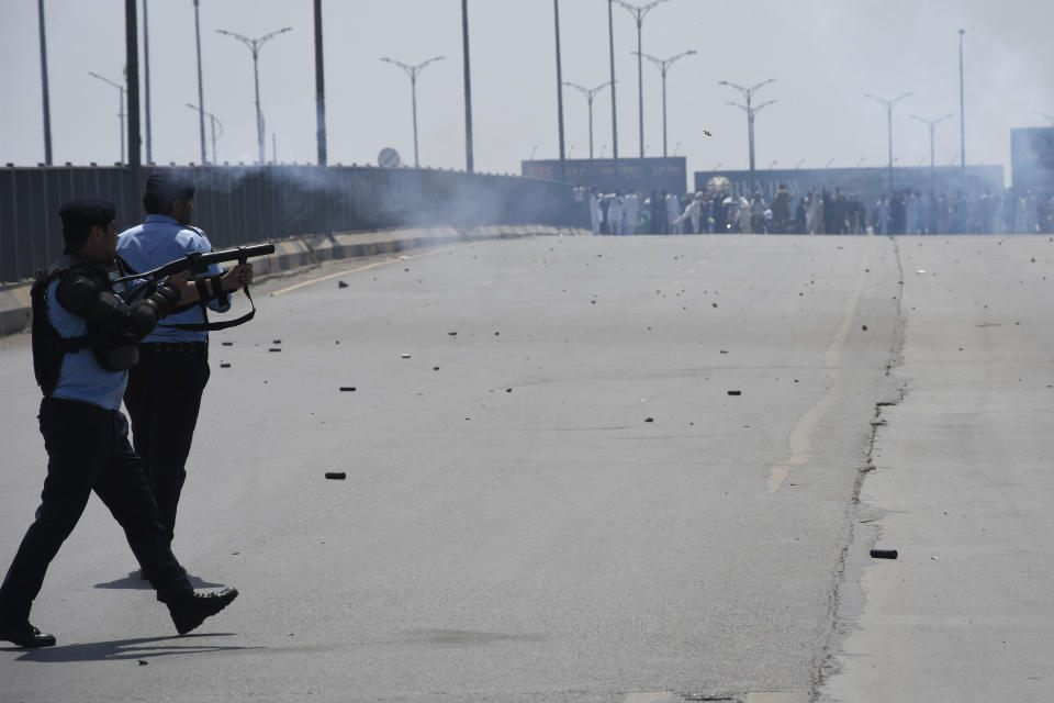 Police officers fire tear gas to disperse the supporters of Pakistan's former Prime Minister Imran Khan during clashes, in Islamabad, Pakistan, Friday, May 12, 2023. A high court in Islamabad has granted Khan a two-week reprieve from arrest in a graft case and granted him bail on the charge. (AP Photo/W.K. Yousafzai)