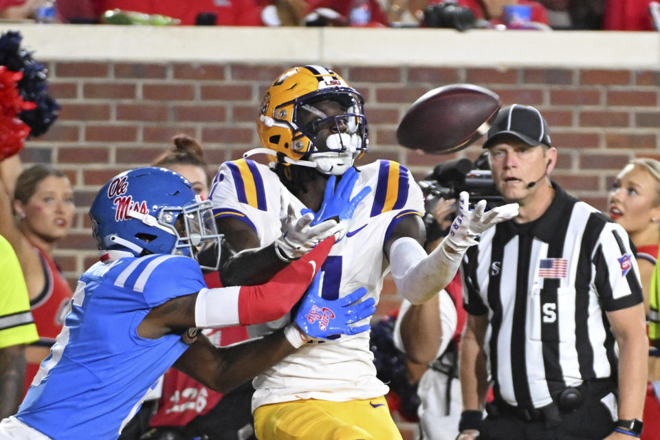 LSU wide receiver Brian Thomas Jr., center, catches a touchdown pass over Mississippi cornerback Zamari Walton, left, during the second half of an NCAA college football game in Oxford, Miss., Saturday, Sept. 30, 2023. (AP Photo/Thomas Graning)