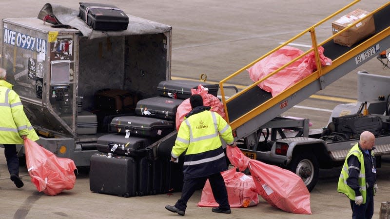 Airport workers remove luggage from an aircraft at London Heathrow Airport on May 18, 2006 in London, England