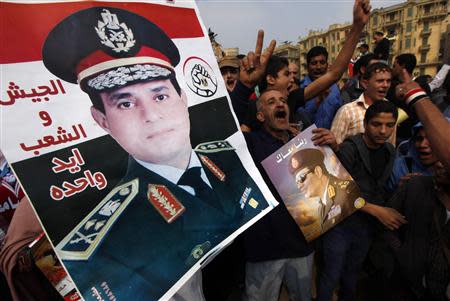 Supporters of Egypt's army chief General Abdel Fattah al-Sisi hold up a poster of Sisi at Tahrir square in downtown Cairo, November 19, 2013, during a rally to commemorate the second anniversary of the deaths of 42 people in clashes with security forces on Mohamed Mahmoud Street nearby. REUTERS/Mohamed Abd El Ghany