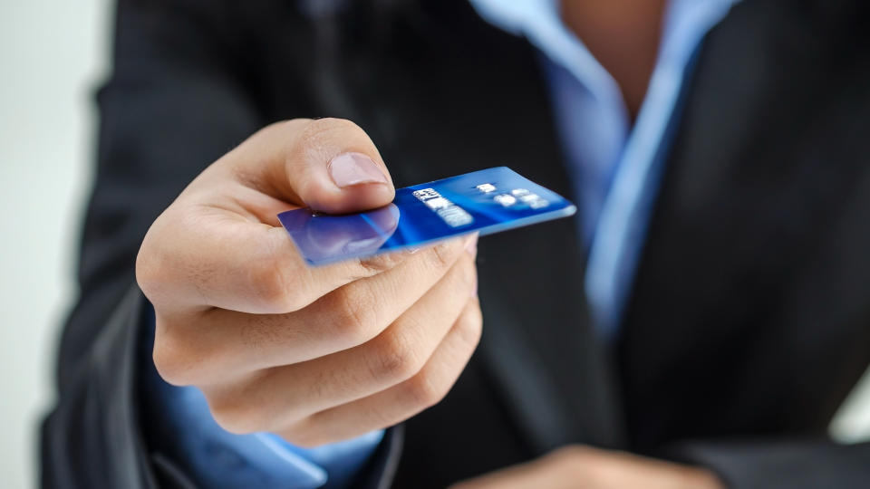 Bank office worker providing credit card.