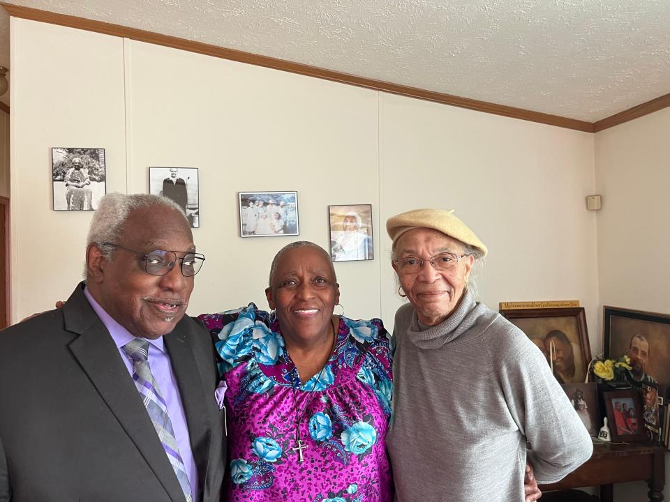 Cousins Charles Smallwood, Bertha Hunt, and Everlyn Holland (right) stand in front of pictures of four generations of family in Hunt's Leonardtown, Maryland, home.