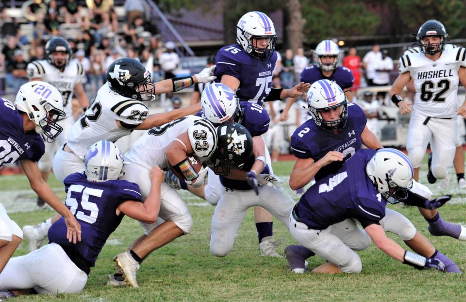 Haskell's Artem Brendle (33) bulls his way for yardage as Cross Plains' Noah Moses (10) and Riley Conlee (55) try to bring him down while Haskell's Cory Mathis (22) helps out. Cross Plains beat the Indians 28-7 on Sept. 10 at Buffalo Stadium in Cross Plains.