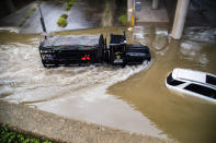 A Houston Police Water Rescue vehicle mobilizes by a stranded by flood car on Houston Ave., during Tropical Storm Beta, Tuesday, Sept. 22, 2020, in Houston. Beta has weakened to a tropical depression as it parked itself over the Texas coast, raising concerns of extensive flooding in Houston and areas further inland. (Marie D. De Jesus/Houston Chronicle via AP)