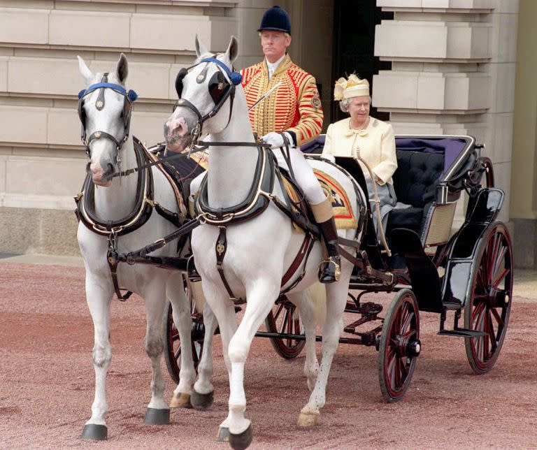 La reina Isabel II sale del Palacio de Buckingham en un carruaje abierto el sábado 14 de junio de 1997 camino al Desfile de la Guardia a Caballo por Trooping the Color. La ceremonia anual se lleva a cabo para celebrar el cumpleaños oficial de la Reina