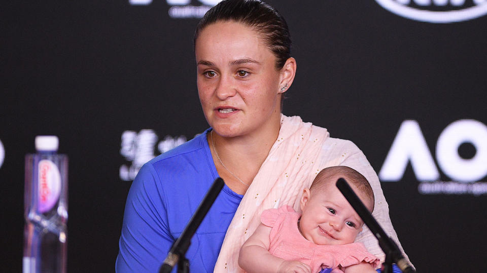 Ashleigh Barty answering questions holding her niece at the Australian Open press conference.