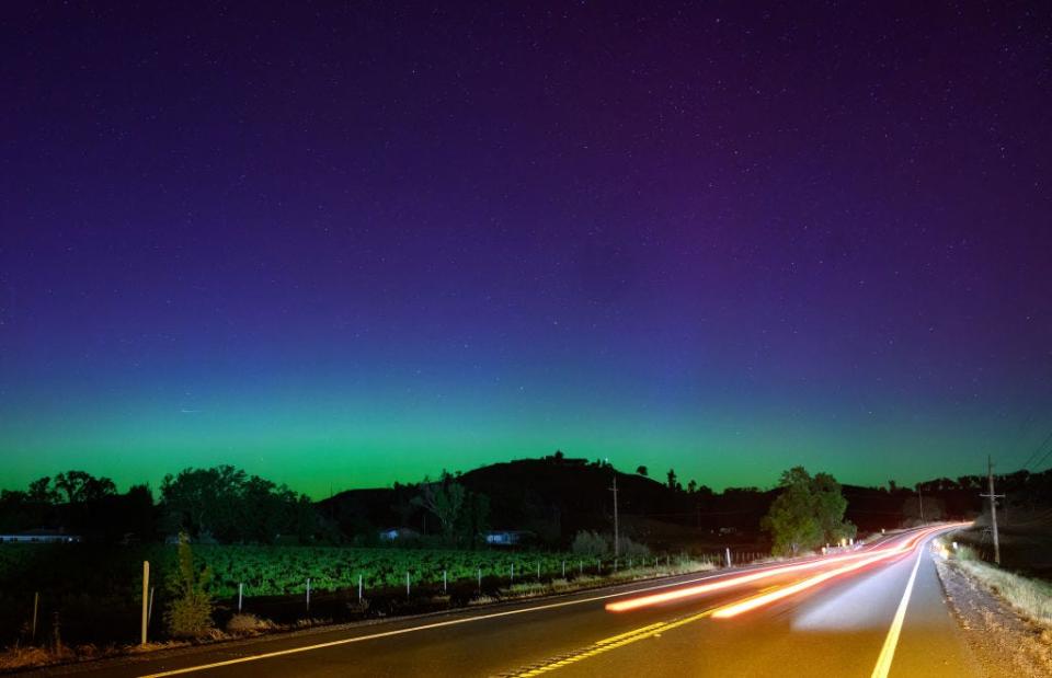 TOPSHOT - Northern lights or aurora borealis illuminate the night sky along a highway north of San Francisco in Middletown, California on May 11, 2024. The most powerful solar storm in more than two decades struck Earth, triggering spectacular celestial light shows from Tasmania to Britain -- and threatening possible disruptions to satellites and power grids as it persists into the weekend. (Photo by JOSH EDELSON / AFP) (Photo by JOSH EDELSON/AFP via Getty Images)