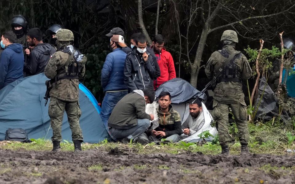 Migrants rest after crossing the border from Belarus into Poland - Czarek Sokolowski /AP