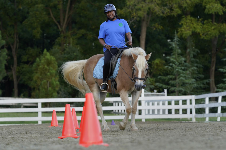 Dionne Williamson, of Patuxent River, Md., participates in a riding lesson at Cloverleaf Equine Center in Clifton, Va., Tuesday, Sept. 13, 2022. After finishing a tour in Afghanistan in 2013, Williamson felt emotionally numb. “It’s like I lost me somewhere,” said the Navy lieutenant commander, who experienced disorientation, depression, memory loss and chronic exhaustion. She eventually found stability through a monthlong hospitalization and a therapeutic program that incorporates horseback riding. But she had to fight for years to get the help she needed. “It's a wonder how I made it through,” she said. (AP Photo/Susan Walsh)