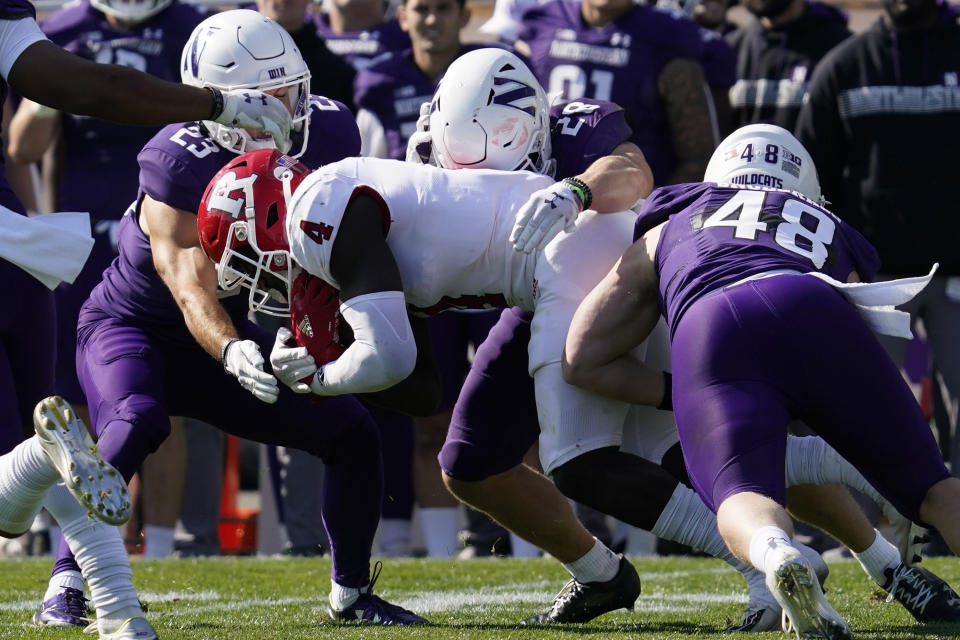 Rutgers running back Aaron Young (4) is tackled by Northwestern's Raymond Niro III (23), linebacker Chris Bergin (28) and linebacker Owen Berginduring (48) during the second half of an NCAA college football game in Evanston, Ill., Saturday, Oct. 16, 2021. Northwestern won 21-7. (AP Photo/Nam Y. Huh)