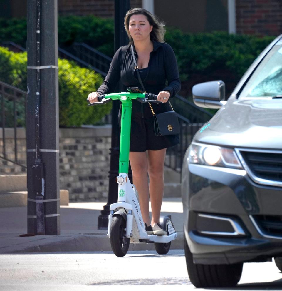 A rider travels down North Broadway at East Kilbourn Avenue on a Lime electric scooter in Milwaukee on Friday, May 17, 2024.