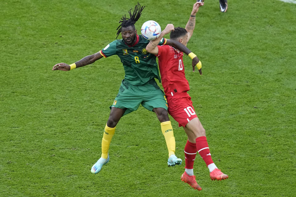 Switzerland's Granit Xhaka, right, jumps for a header with Cameroon's Andre-Frank Zambo Anguissa during the World Cup group G soccer match between Switzerland and Cameroon, at the Al Janoub Stadium in Al Wakrah, Qatar, Thursday, Nov. 24, 2022. (AP Photo/Ebrahim Noroozi)