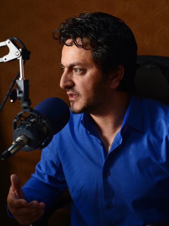 Afghan radio presenter Masood Sanjer talks during the "Safai Shahar" (Cleaning the City) show at the Arman FM radio station in Kabul on June 10, 2014