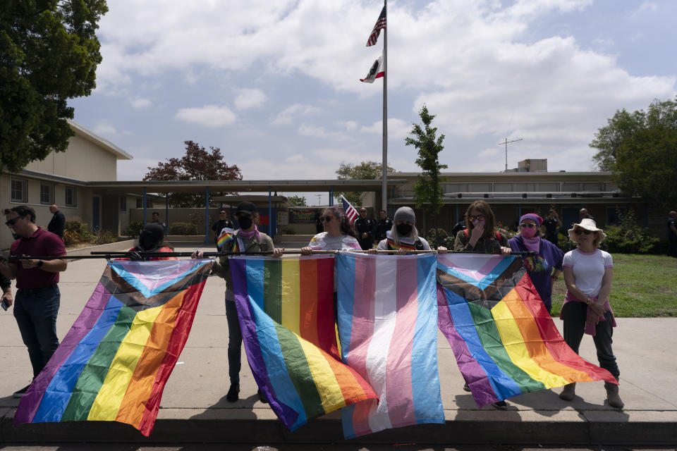 People with Pride flags stand outside Saticoy Elementary School in Los Angeles, Friday, June 2, 2023. Police officers separated groups of protesters and counterprotesters outside the elementary school that has become a flashpoint for Pride month events across California. (AP Photo/Jae C. Hong)