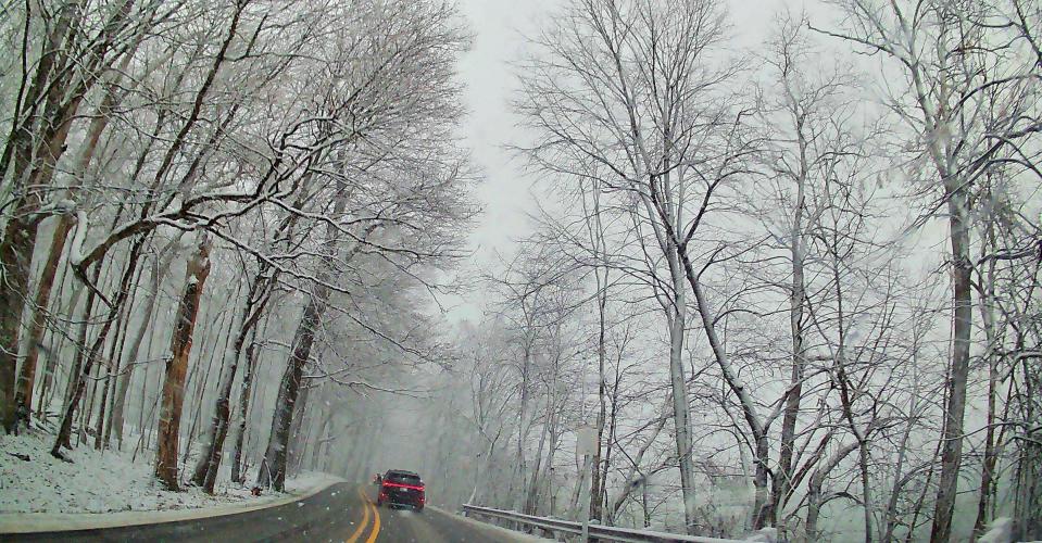 A vehicle slowly winds through Old Orchard Trail in Orchard Lake Village on Friday, Jan. 12, 2024, during metro Detroit’s first winter storm of the year.