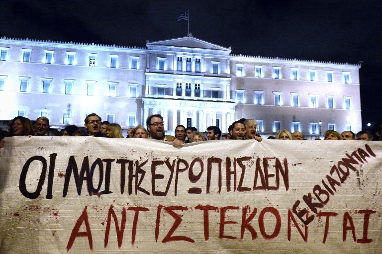 People hold a banner reading "People of Europe won't be blackmailed, they will resist" in front of parliament in Athens on February 5, 2015 in support of the new anti-austerity government