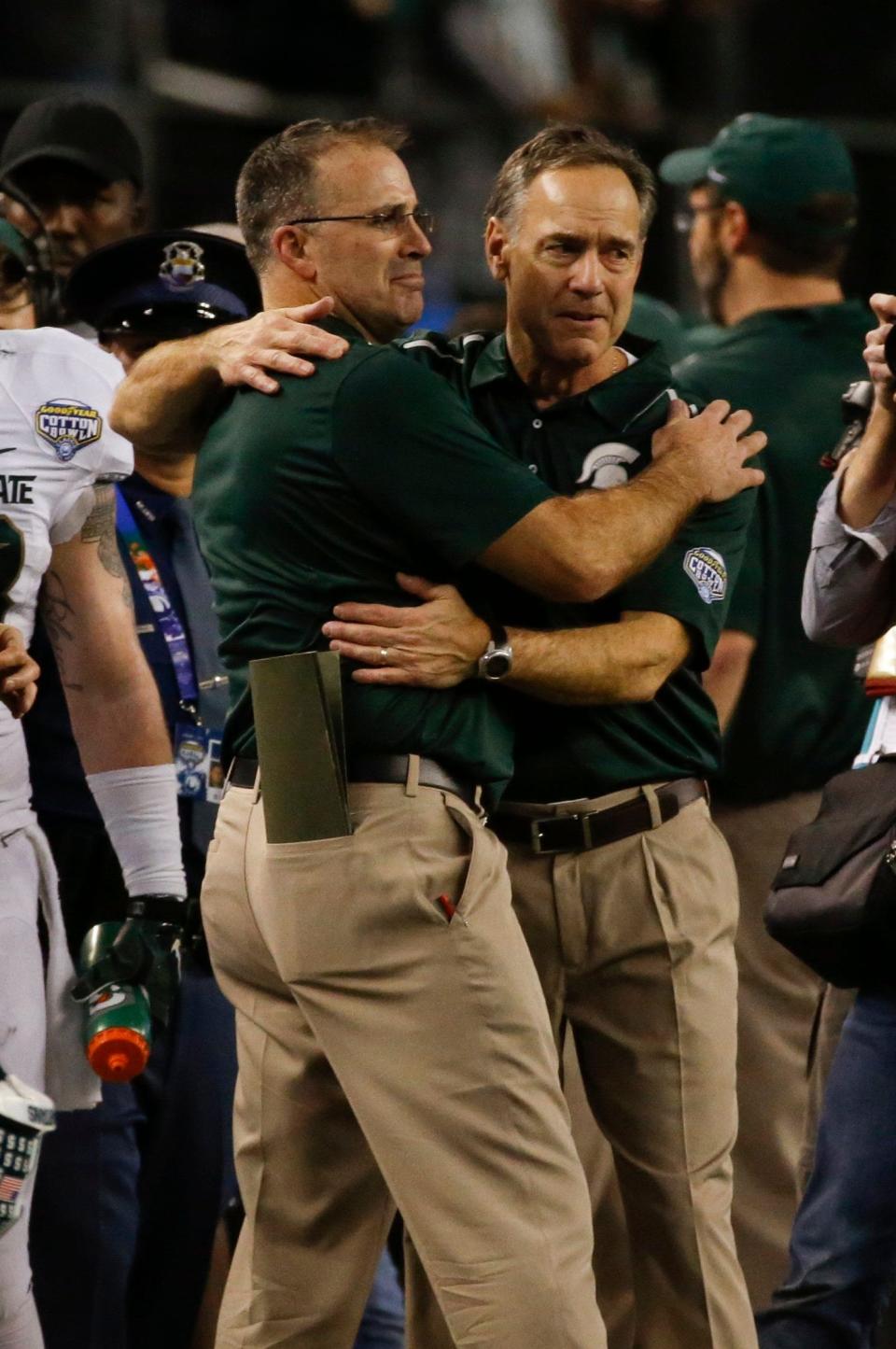 Michigan State head coach Mark Dantonio hugs defensive coordinator Pat Narduzzi following MSU's 42-41 victory over Baylor in the Cotton Bowl Classic. It was Narduzzi's final game with the Spartans, as he will take over as head coach at Pittsburgh.