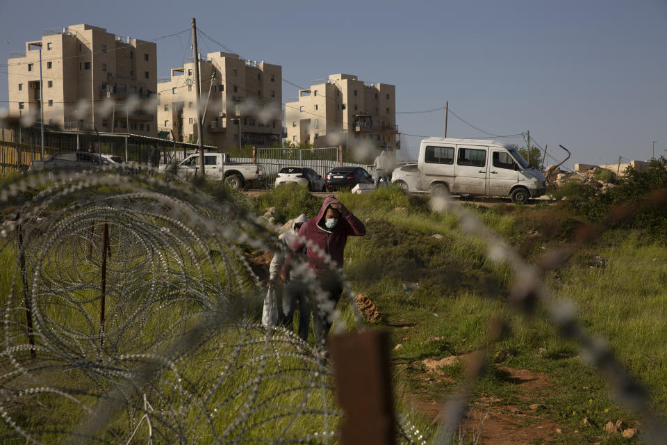 Palestinian laborers head home after their work day on construction projects in the West Bank Jewish settlement of Efrat, Tuesday, March 16, 2021. Israel went on an aggressive settlement spree during the Trump era, according to an AP investigation, pushing deeper into the occupied West Bank than ever before and putting the Biden administration into a bind as it seeks to revive Mideast peace efforts. (AP Photo/Maya Alleruzzo)