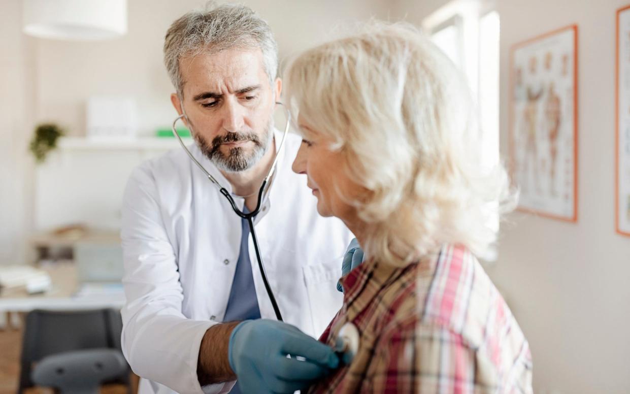 Healthy woman in her 60s being examined by a doctor with a stethoscope