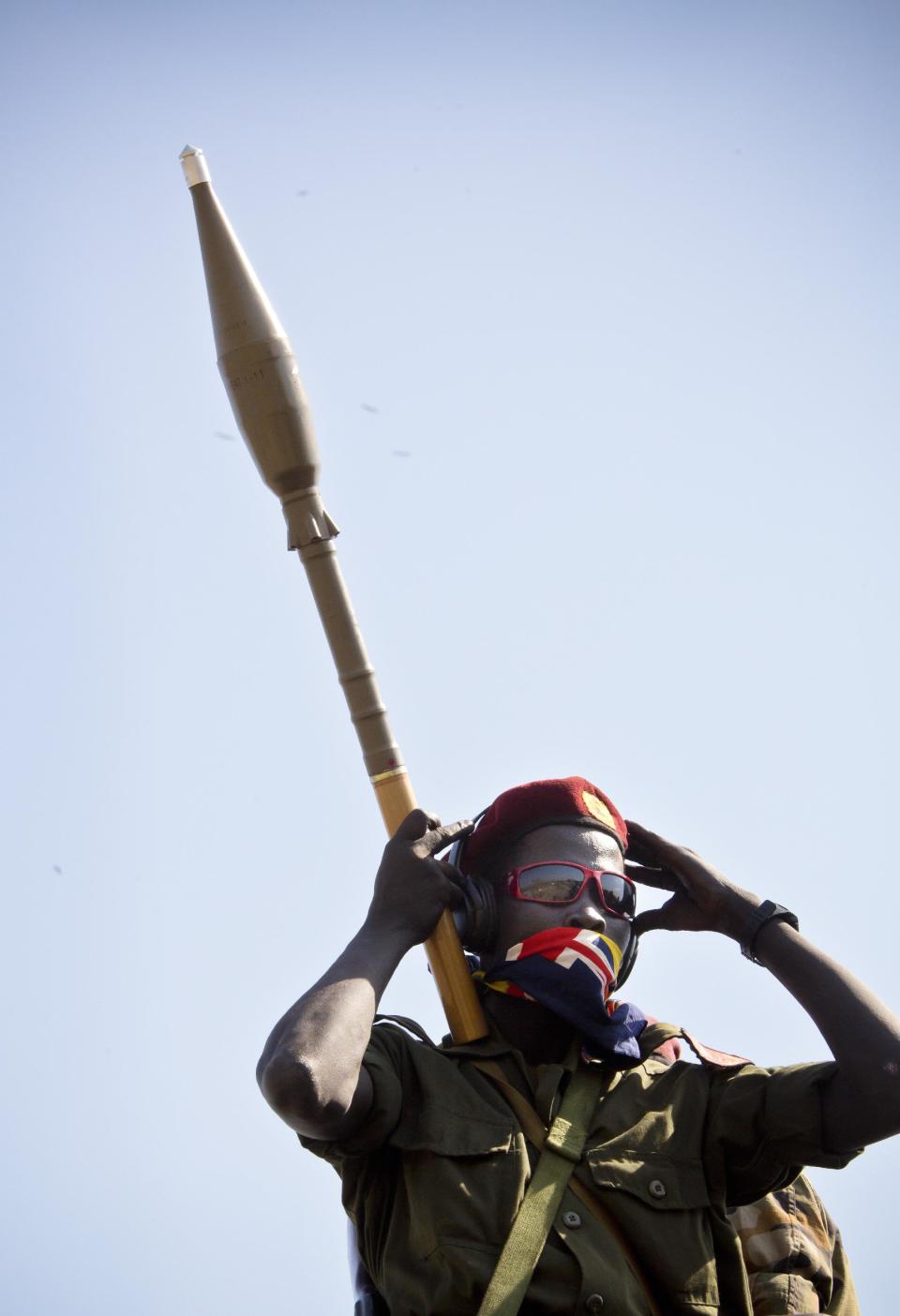 A government soldier holding a rocket-propelled grenade (RPG) launcher rides on a truck, towards the frontline, to reinforce government forces already fighting rebel forces near the town of Bor, as they prepare to leave from the outskirts of Juba, South Sudan, Monday, Jan. 13, 2014. Despite the appearance of diplomatic progress, the conflict seems set to continue as South Sudan government troops are moving in on Bor which is currently held by rebels. (AP Photo/Jake Simkin)