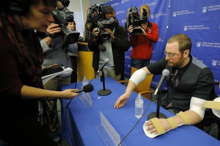 Will Lautzenheiser demonstrates some of the motion in his right arm at a news conference to announce his successful double arm transplant at Brigham and Women's Hospital in Boston, Massachusetts November 25, 2014. REUTERS/Brian Snyder
