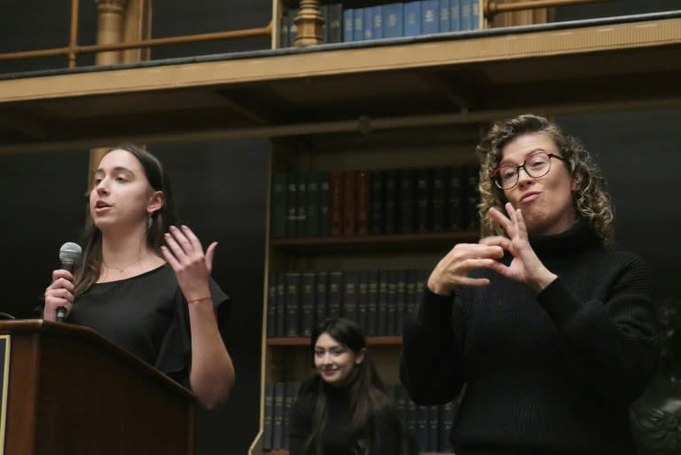 An interpreter signs in American Sign Language during a debate between Gallaudet University’s debate team and the Philodemic Society, Georgetown University’s debate club, at the Riggs Library in Washington, DC, on April 11, 2024 (Amel SEMMACHE)