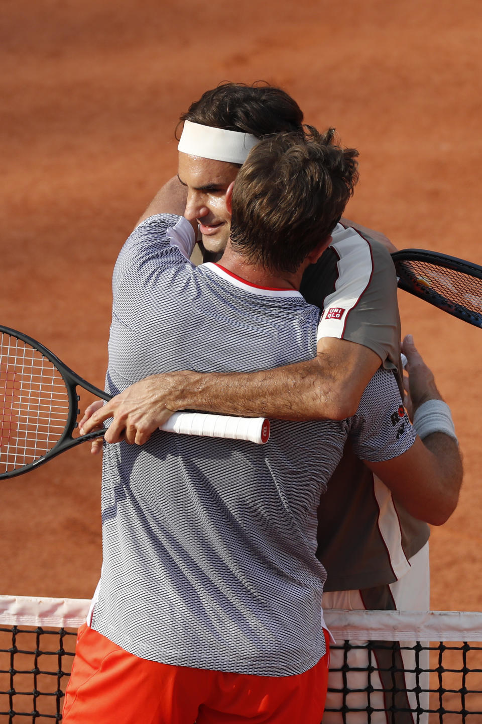 Switzerland's Roger Federer and Switzerland's Stan Wawrinka hug after their quarterfinal match of the French Open tennis tournament against which Federer won in four sets, 7-6 (7-4), 4-6, 7-6 (7-5), 6-4, at the Roland Garros stadium in Paris, Tuesday, June 4, 2019. (AP Photo/Jean-Francois Badias)