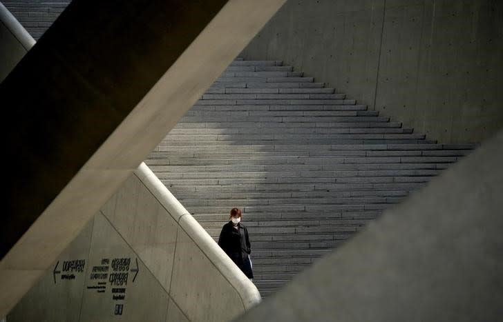 A woman wearing a protective face mask to prevent contracting the coronavirus disease (COVID-19) walks stairs in Seoul