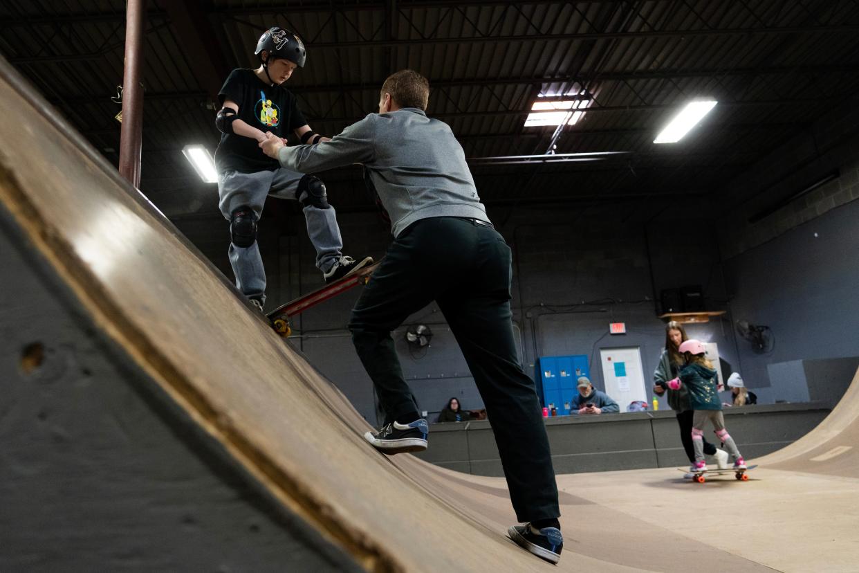 Novak Jackson, 11, drops in on the quarter pipe Sunday, March 5, 2023, with the help of Brian Apolskis, co-owner and teacher at Q Skatepark in the Stout Army Field neighborhood in Indianapolis. Brian has run the park for six years with his wife Shane and sees it as the “Little League” for Indianapolis’s larger skate scene. 