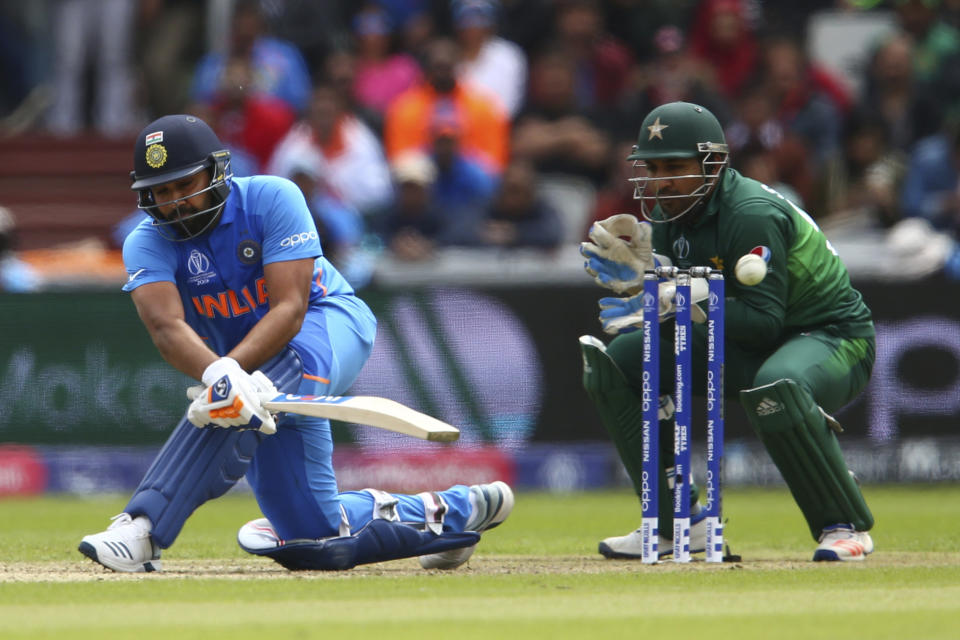 India's Rohit Sharma plays a shot under the watch of Pakistan's captain Sarfaraz Ahmed during the Cricket World Cup match between India and Pakistan at Old Trafford in Manchester, England, Sunday, June 16, 2019. (AP Photo/Dave Thompson)