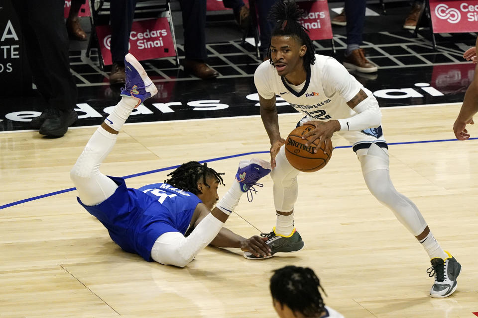 Los Angeles Clippers guard Terance Mann, right, falls down while guarding Memphis Grizzlies guard Ja Morant (12) during the first half of an NBA basketball game Wednesday, April 21, 2021, in Los Angeles. (AP Photo/Marcio Jose Sanchez)