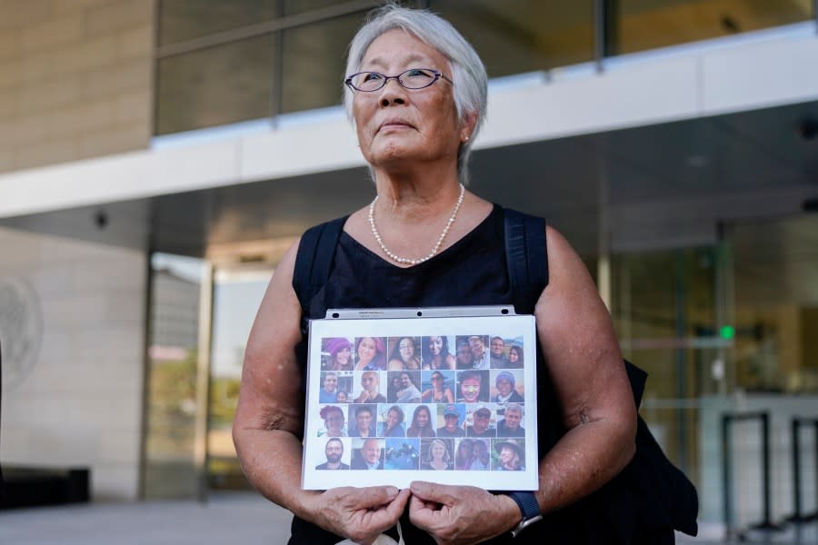 FILE – Barbara Chan, whose brother Raymond “Scott” Chan was among the 34 victims of a fire on the scuba dive boat Conception, holds up a photo of the victims, Oct. 24, 2023, in Los Angeles. The captain of the boat is scheduled to be sentenced by a federal judge Thursday, May 2, 2024, on a conviction of criminal negligence. (AP Photo/Ryan Sun, File)