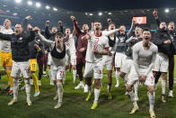 Poland players celebrate after defeating Wales in a penalty shoot out during their Euro 2024 soccer play-off match at Cardiff City Stadium, Wales, Tuesday, March 26, 2024. (AP Photo/Alastair Grant)