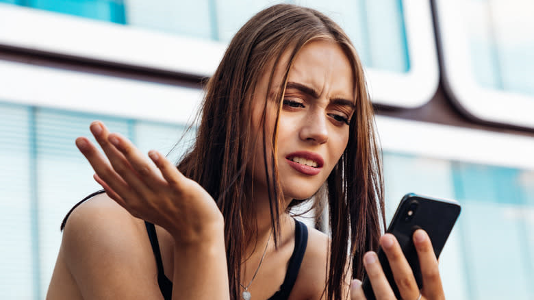 young woman annoyed with her phone
