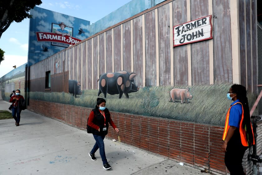 VERNON, CA -- MAY 29: Workers exit the building at the Smithfield Foods-owned Farmer John plant on Friday, May 29, 2020, in Vernon, CA. Their, 153 of 1,837 employees tested positive for COVID-19 between March and May, Los Angeles County officials said. (Gary Coronado / Los Angeles Times)