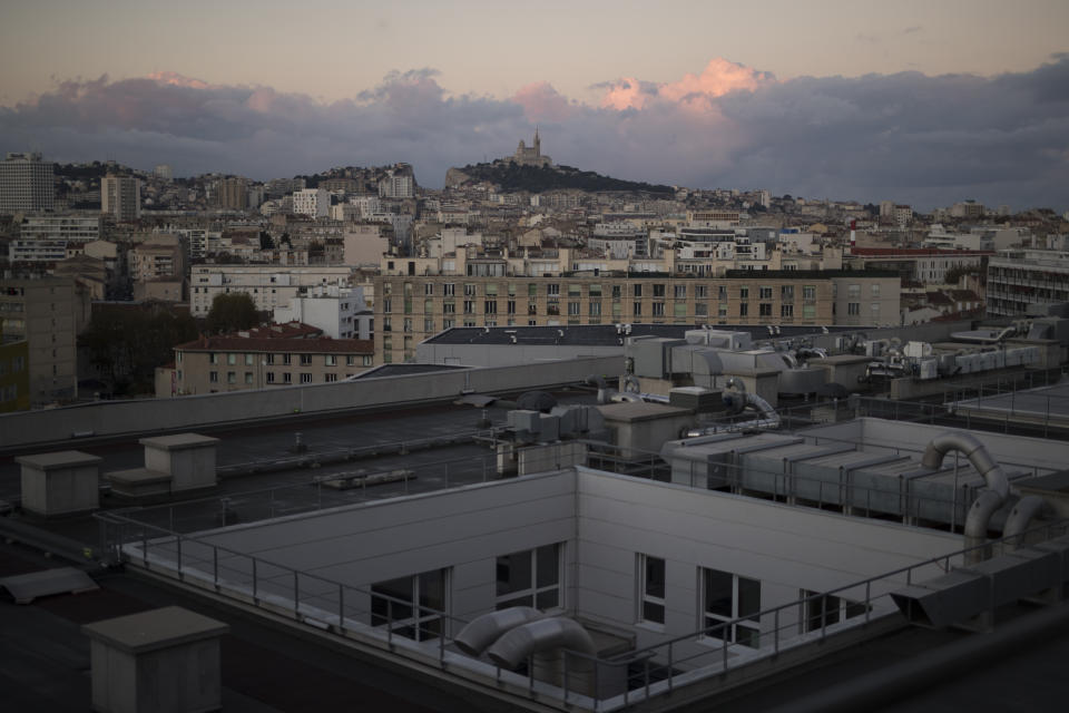 Marseille's Notre-Dame de la Garde basilica is pictured from the roof of the La Timone hospital at sunrise. Friday, Nov. 13, 2020. France is more than two weeks into its second coronavirus lockdown, and intensive care wards have been over 95% capacity for more than 10 days now. Marseille has been submerged with coronavirus cases since September. (AP Photo/Daniel Cole)