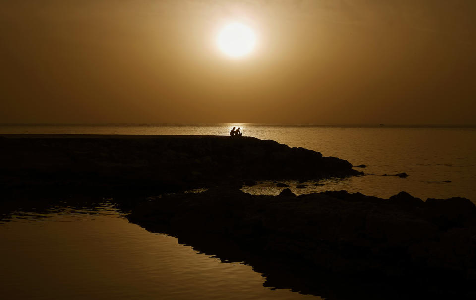 Couple near sea during sunset