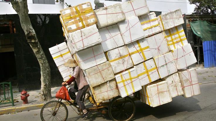 A cyclist carts dozens of foam boxes on the back of their bike. Photo: Reuters